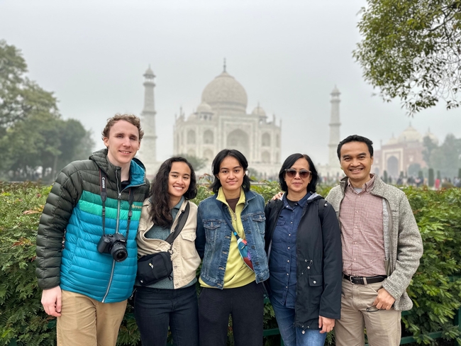 My family and I stand together in front of the Taj Mahal, enveloped in a gentle fog.